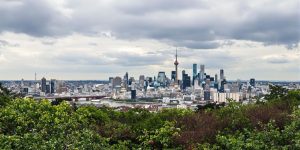 Oraș modern cu nori și natură în prim-plan.